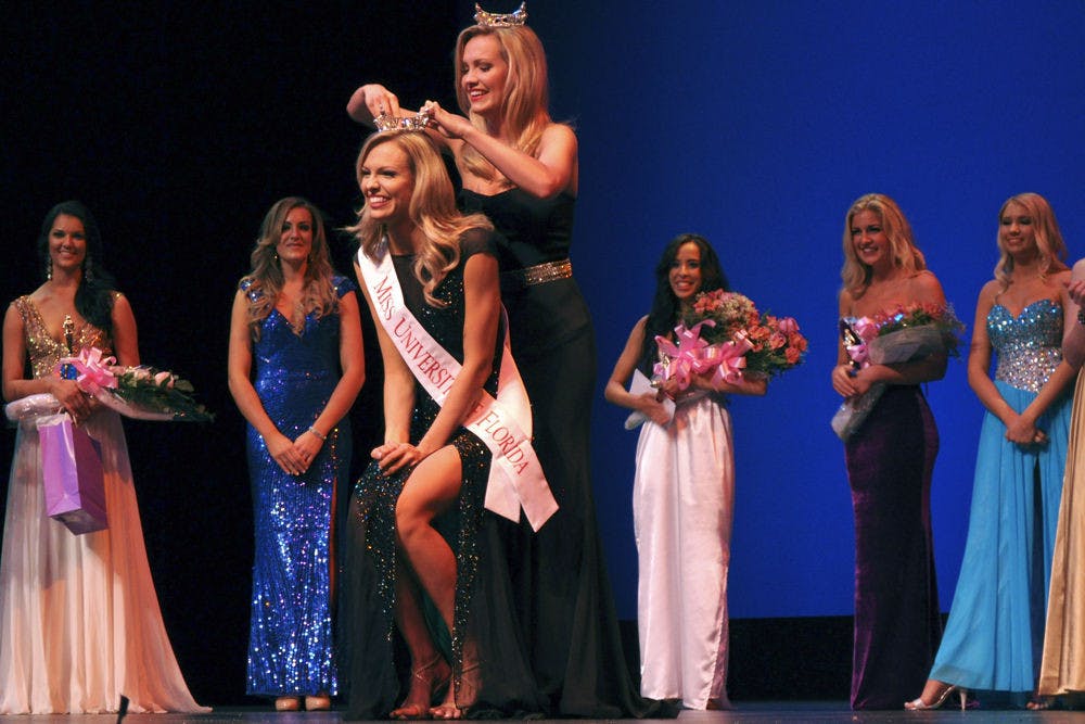 <p>Mary Katherine Fechtel (center left) is crowned 2015 Miss UF by her sister and 2014 Miss UF, Elizabeth Fechtel, at the 2015 Miss University of Florida Scholarship Pageant in the Phillips Center for the Performing Arts on Monday night.</p>