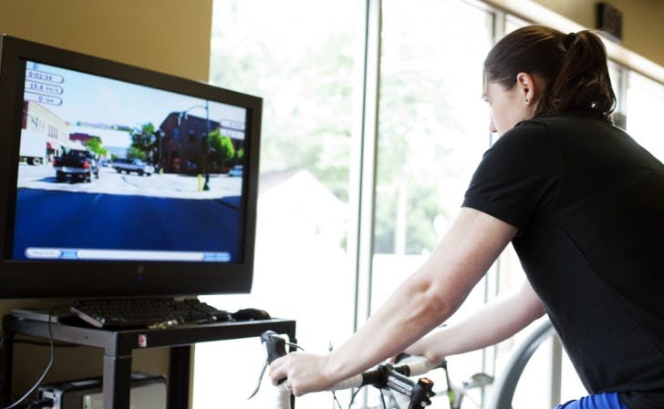 Amie Buehler, a 23-year-old applied physiology and kinesiology senior and intern at Shands Fitness and Wellness Center, demonstrates how the Virtual Tour de Shands operates Wednesday afternoon.