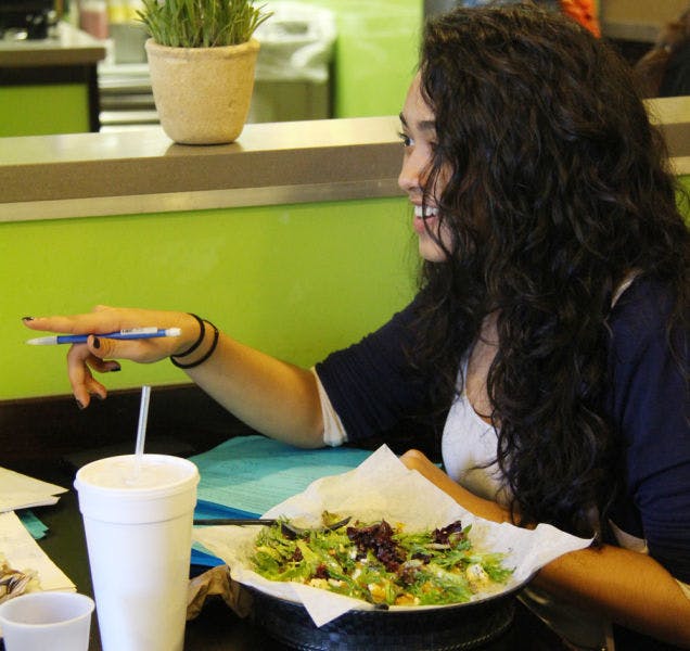 Nicole Manugas, an then-18-year-old UF neuroscience freshman, studies Wednesday while eating a salad at Designer Greens.&nbsp;
