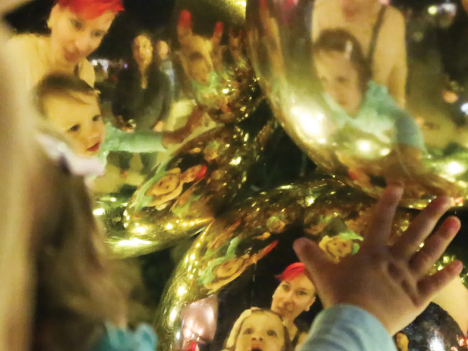 Kelly Anderson, a 30-year-old clinical lab scientist, and Olivia Hamner, 14 months old, look at their reflections on Christmas decorations after the tree lighting ceremony on Nov. 29, 2015.