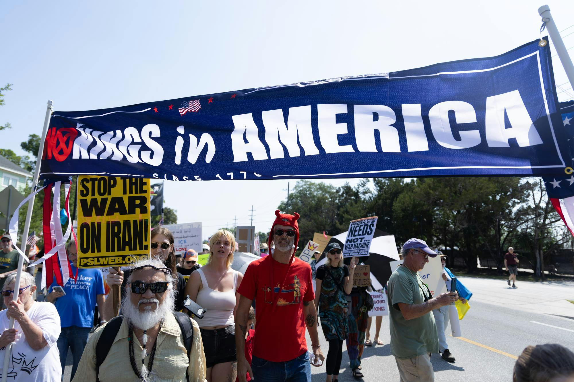 Protesters march with banners and signs towards Cora. P Roberson Park, Saturday, March 28, 2026, in Gainesville, Fla.