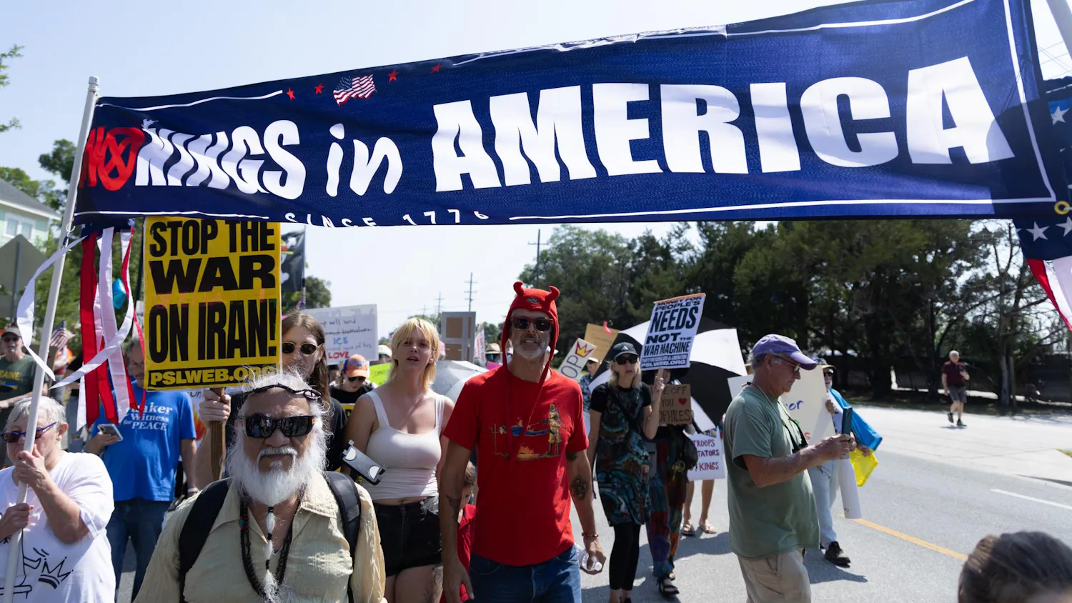 Protesters march with banners and signs towards Cora. P Roberson Park, Saturday, March 28, 2026, in Gainesville, Fla.