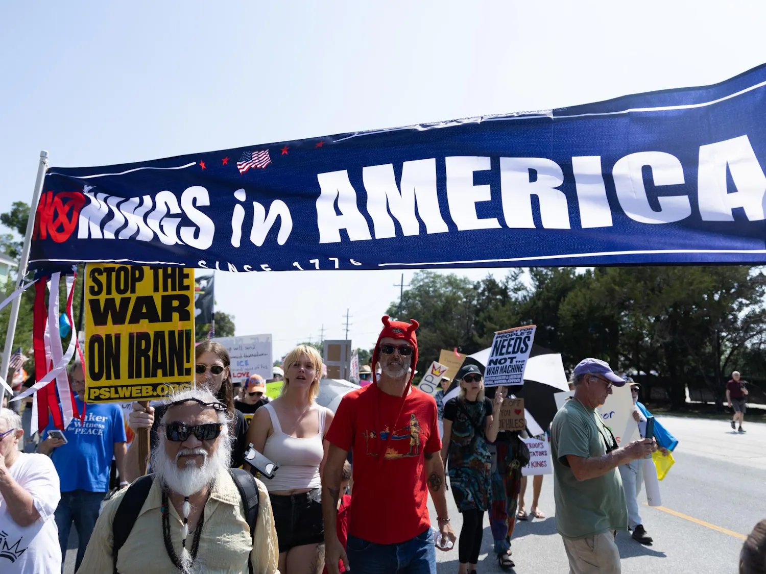 Protesters march with banners and signs towards Cora. P Roberson Park, Saturday, March 28, 2026, in Gainesville, Fla.