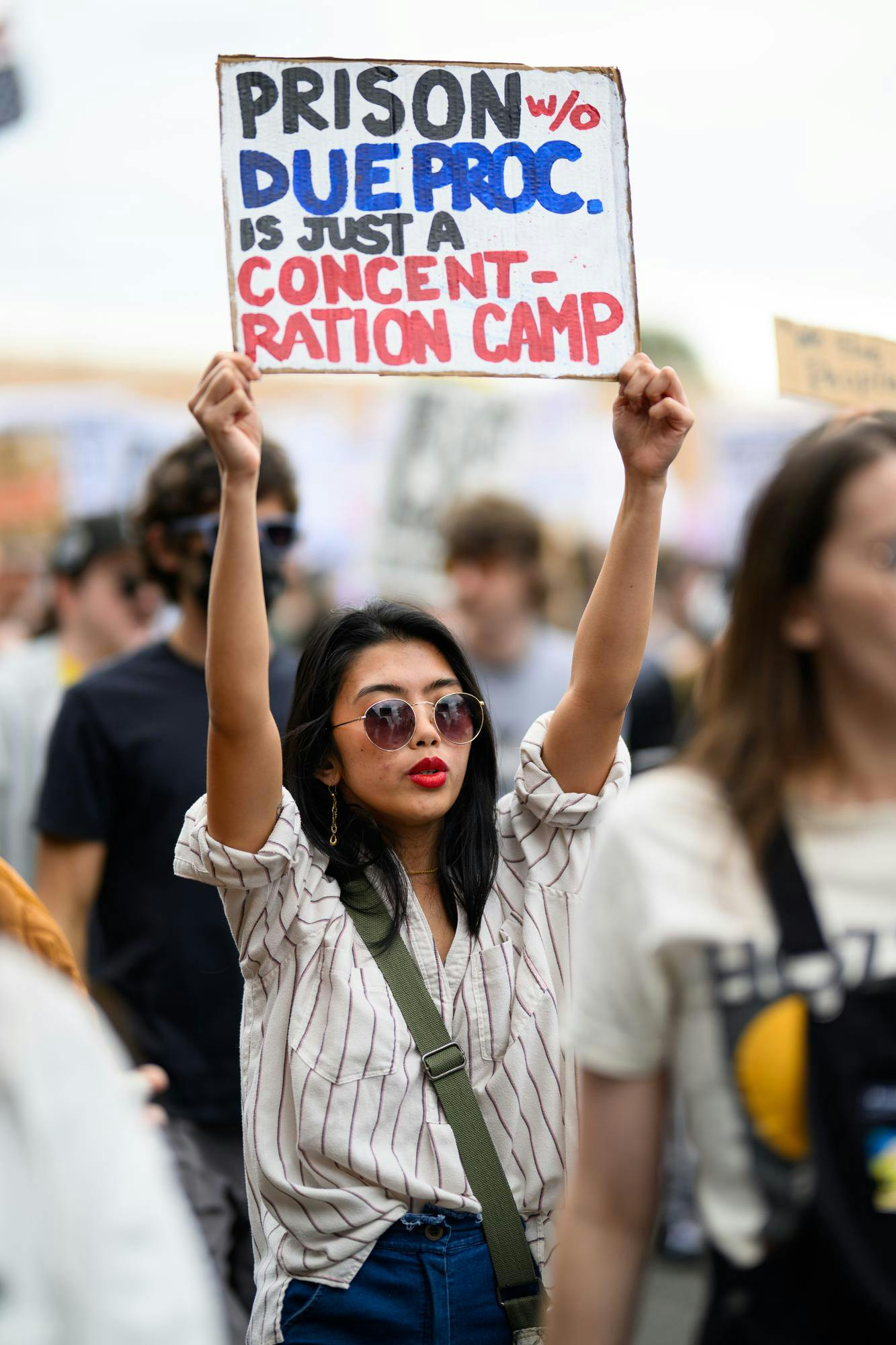 A demonstrator holds a sign during an ICE protest organized by YDSA, Friday, Jan. 30, 2026, along University Avenue in Gainesville, Fla.