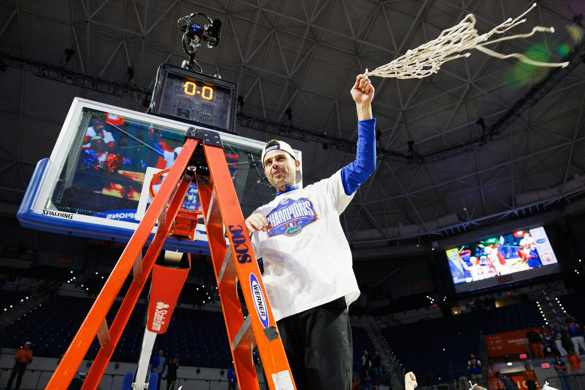 Florida head coach Todd Golden swings the net in the air after clinching the SEC regular season title following a win in an NCAA college basketball game against Arkansas, Saturday, Feb. 28, 2026, in Gainesville, Fla.