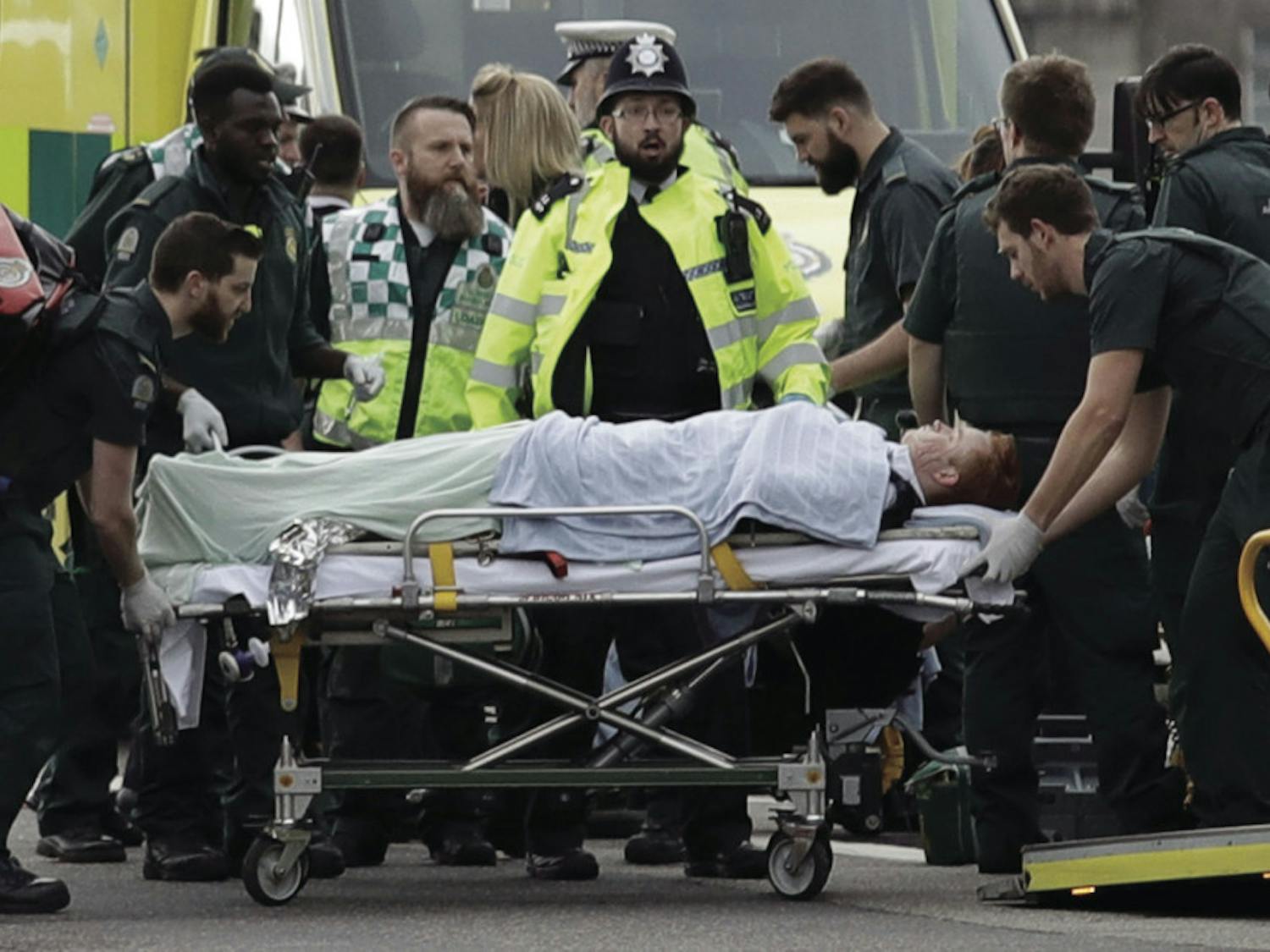 Emergency services staff provide medical attention to injured people on the south side of Westminster Bridge, close to the Houses of Parliament in London, Wednesday, March 22, 2017. London police say they are treating a gun and knife incident at Britain's Parliament "as a terrorist incident until we know otherwise." The Metropolitan Police says in a statement that the incident is ongoing. Officials say a man with a knife attacked a police officer at Parliament and was shot by officers. Nearby, witnesses say a vehicle struck several people on the Westminster Bridge. 