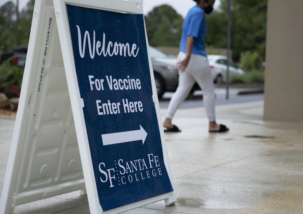 A student walks into Santa Fe College Jackson N. Sasser Fine Arts Hall, where hosts a COVID vaccine event on Thursday morning 9 a.m., May 13, 2021, at the Jackson N. Sasser Fine Arts Hall on SF’s Northwest Campus for people to get their second vaccine.