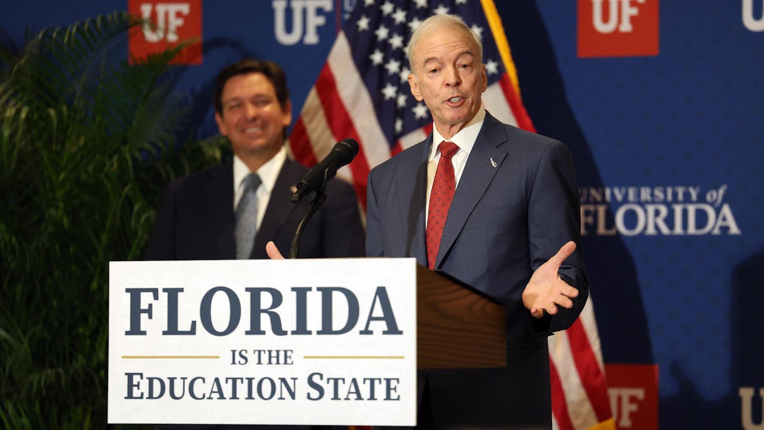 Interim University of Florida President Dr. Donald Landry speaks as Gov. Ron DeSantis smiles in the background at Emerson Alumni Hall on the university’s campus on Monday, Sept. 29, 2025.