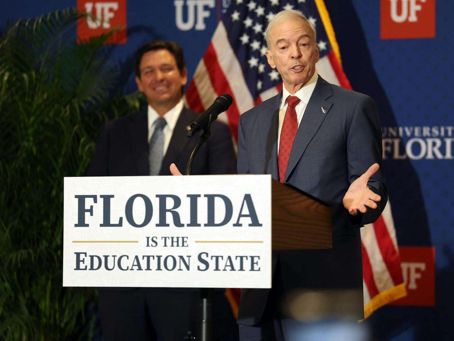 Interim University of Florida President Dr. Donald Landry speaks as Gov. Ron DeSantis smiles in the background at Emerson Alumni Hall on the university’s campus on Monday, Sept. 29, 2025.