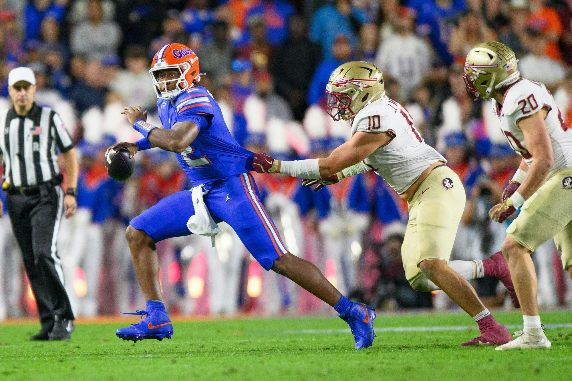 Florida quarterback DJ Lagway (2) gets his jersey grabbed by Florida State defensive lineman James Williams (10) during the first half of an NCAA college football game, Saturday, Nov. 29, 2025, at Ben Hill Griffin Stadium in Gainesville, Fla.