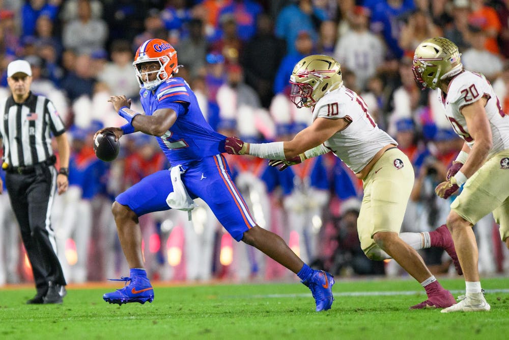 Florida quarterback DJ Lagway (2) gets his jersey grabbed by Florida State defensive lineman James Williams (10) during the first half of an NCAA college football game, Saturday, Nov. 29, 2025, at Ben Hill Griffin Stadium in Gainesville, Fla.