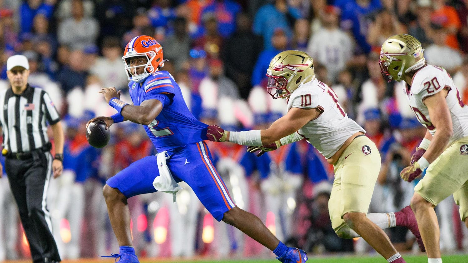 Florida quarterback DJ Lagway (2) gets his jersey grabbed by Florida State defensive lineman James Williams (10) during the first half of an NCAA college football game, Saturday, Nov. 29, 2025, at Ben Hill Griffin Stadium in Gainesville, Fla.