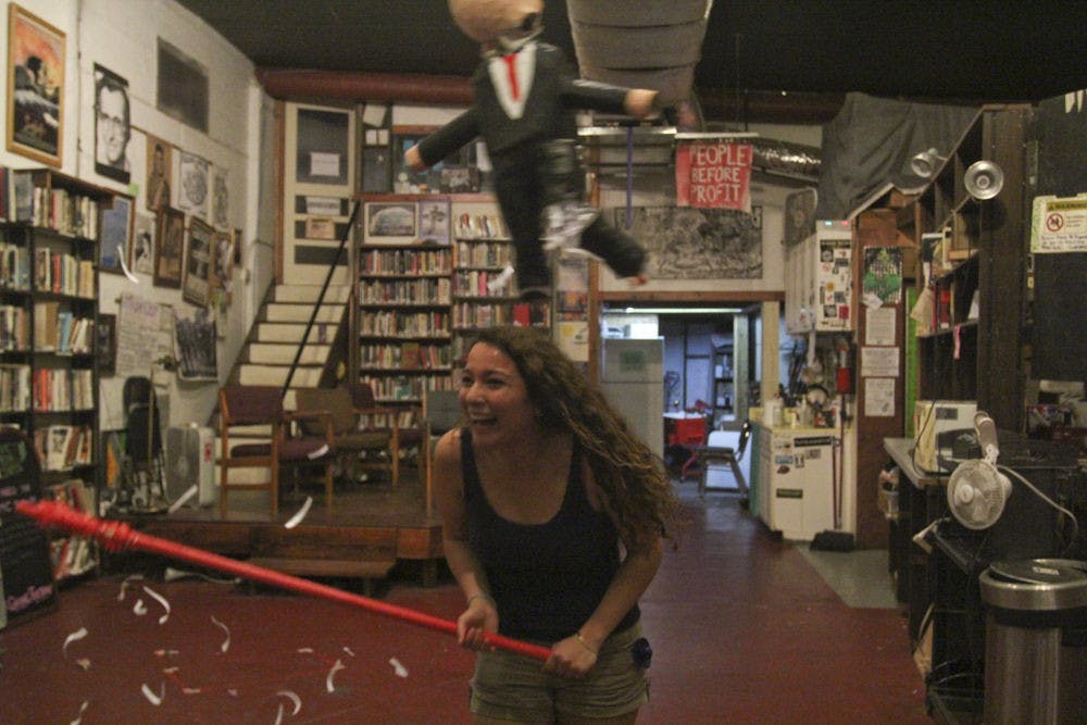 <p>Paloma Mendez, a UF Spanish senior, swings at a Donald Trump-shaped piñata created by visiting artist Ana Trevino at the Civic Media Center on Nov. 21, 2015. There were about 25 people attending.</p>