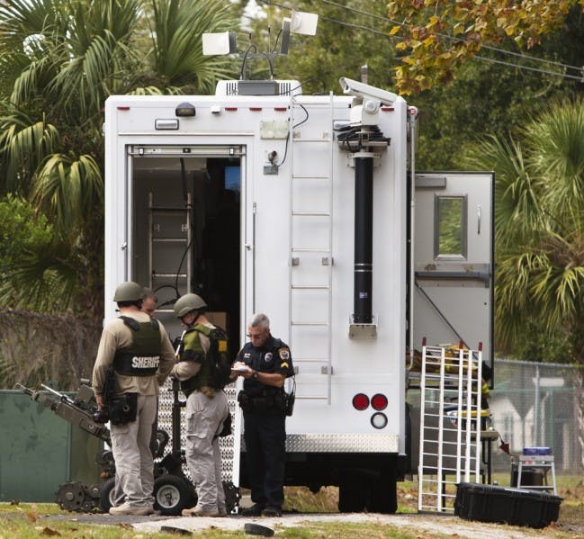 Officers from the Alachua County Sheriff's Office Bomb Disposal Team investigate a suspicious explosive device at Oxford Terrace II located off Southwest Depot Avenue on Friday afternoon.