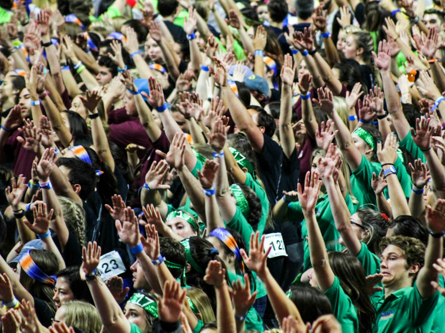 Dancers raise their hands during a dance number at 2017's Dance Marathon at the O'Connell Center. Dance Marathon raises money and awareness for Children's Miracle Network.