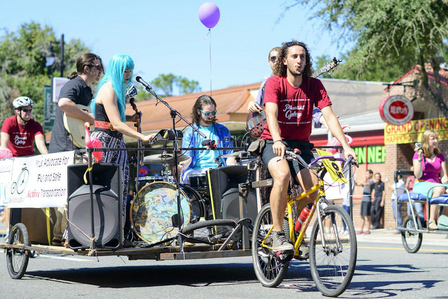 Sergei Max Hubscher Cook of Pleasant Cyclery pulls the local cosmic-funk pop band Flat Land in the UF Homecoming Parade while promoting Get Active GNV, which advocates for fun and safe active transportation.&nbsp;