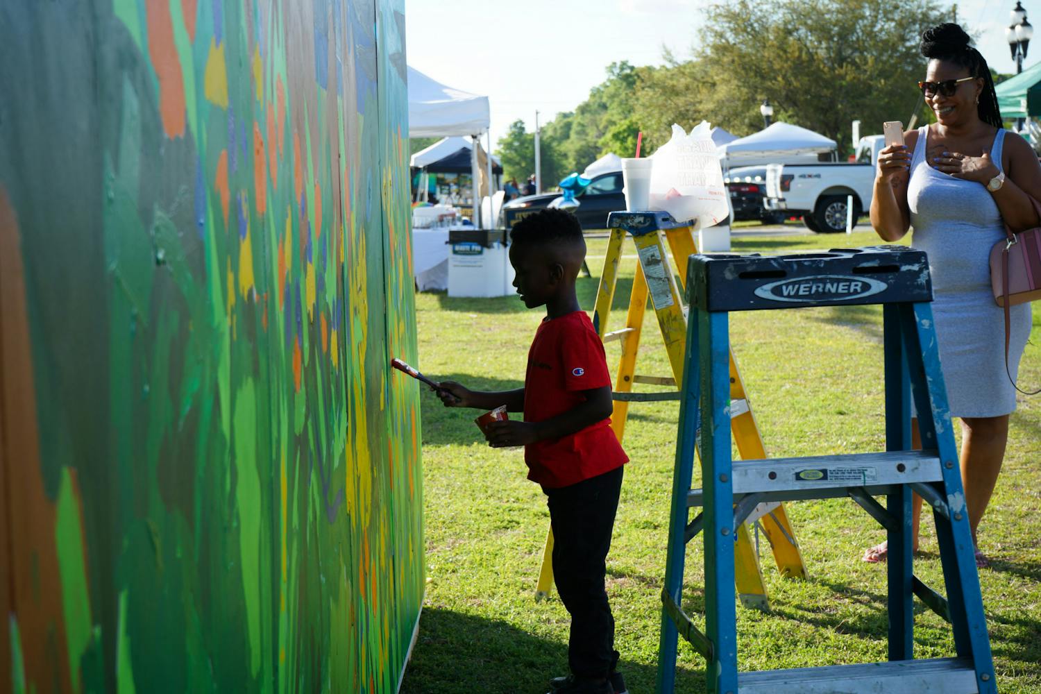 A little boy paints the kids mural setup at the Walldogs Mural Painting festival in High Springs Friday, March 24, 2023.