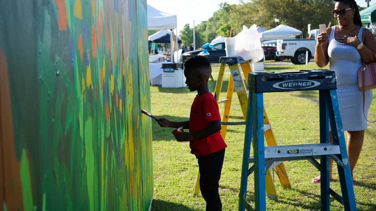 A little boy paints the kids mural setup at the Walldogs Mural Painting festival in High Springs Friday, March 24, 2023.