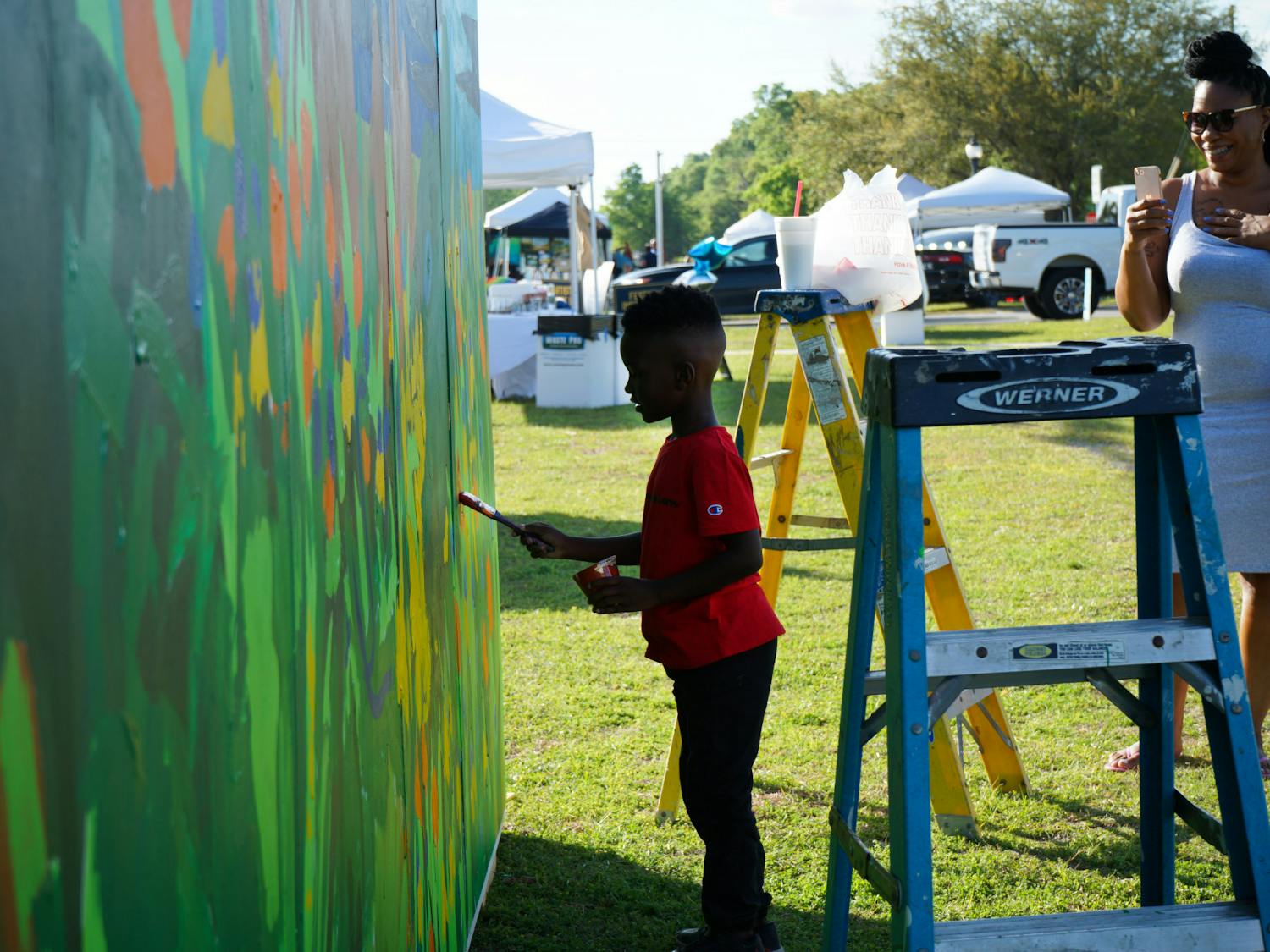 A little boy paints the kids mural setup at the Walldogs Mural Painting festival in High Springs Friday, March 24, 2023.
