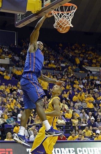 Florida guard Kenny Boynton, top, dunks the ball in front of LSU guard Charles Carmouche during the second half of an NCAA college basketball game at the Pete Maravich Assembly Center in Baton Rouge, La., Saturday, Jan. 12, 2013. Florida won 74-52.(AP Photo/Bill Feig)