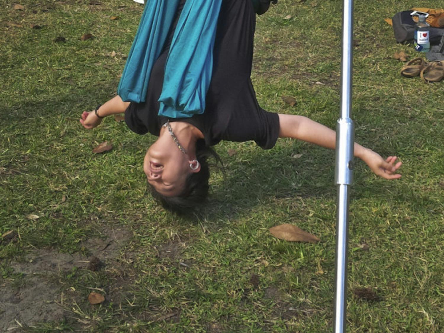 Eun Jin Chun, a UF linguistics doctoral student, tries aerial hammock yoga at “Stress Free with SG” on Dec. 3, 2015. The 37-year-old said after seeing other students doing it on the Plaza of the Americas, she wanted to try the activity herself.
