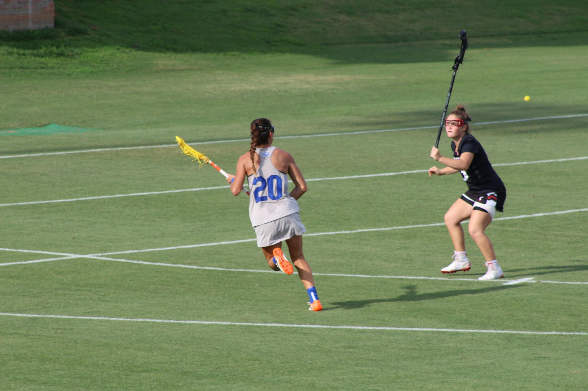 Florida's Brianna Harris (pictured, No. 20) makes a move on a Cincinnati defender during the AAC Championship on May 8. Harris scored six goals and added four assists in the title game.