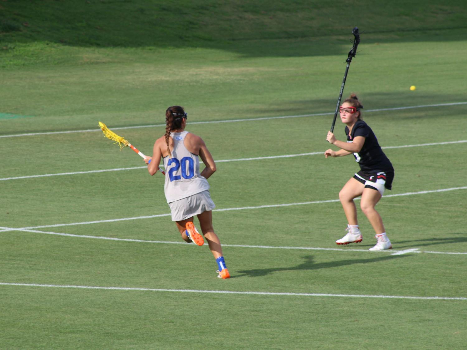 Florida's Brianna Harris (pictured, No. 20) makes a move on a Cincinnati defender during the AAC Championship on May 8. Harris scored six goals and added four assists in the title game.