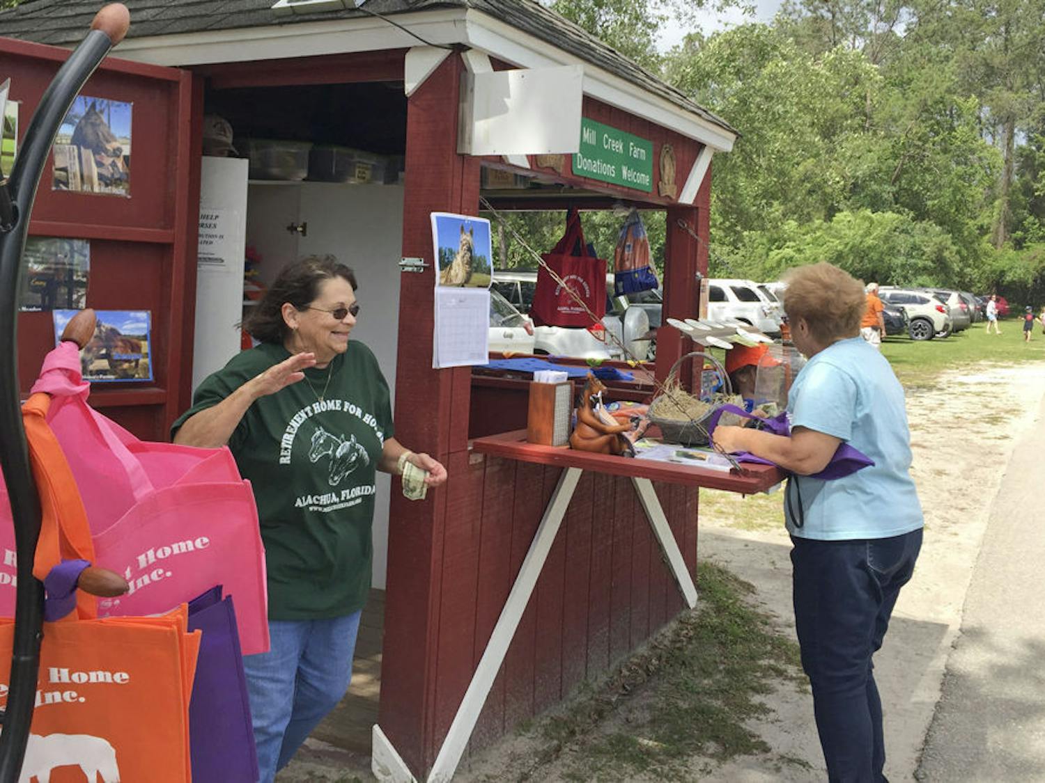 Lynne Brennan, a volunteer at Mill Creek since July 2012, greets a visitor at the farm. Brennan typically works the welcome kiosk on Saturdays.