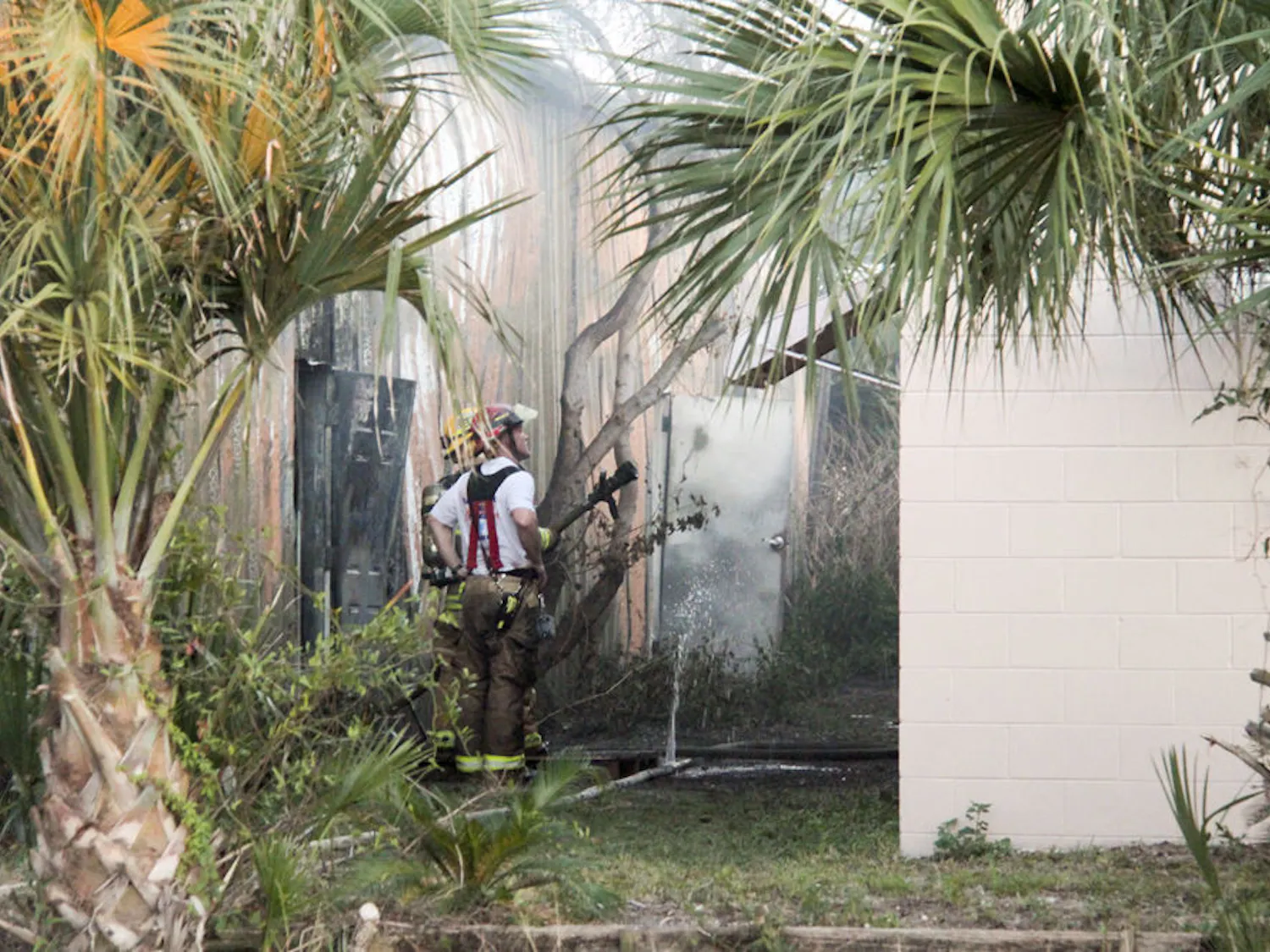 Gainesville Fire Rescue Lt. D.G. Campbell Jr. stands with another firefighter as he sprays water on a building neighboring Mica-Mode Cabinetry that caught fire at about 4 p.m. Wednesday. No one was injured in the fire, according to Gainesville Fire Rescue Assistant Chief JoAnne Rice.