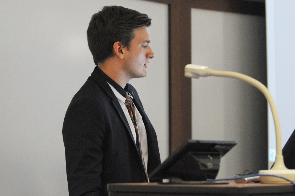 <p>Ty Robare, comprehensive statute reform ad hoc committee chairman, gives his committee report at Tuesday's Student Senate meeting prior to the second reading of the reforms.</p>