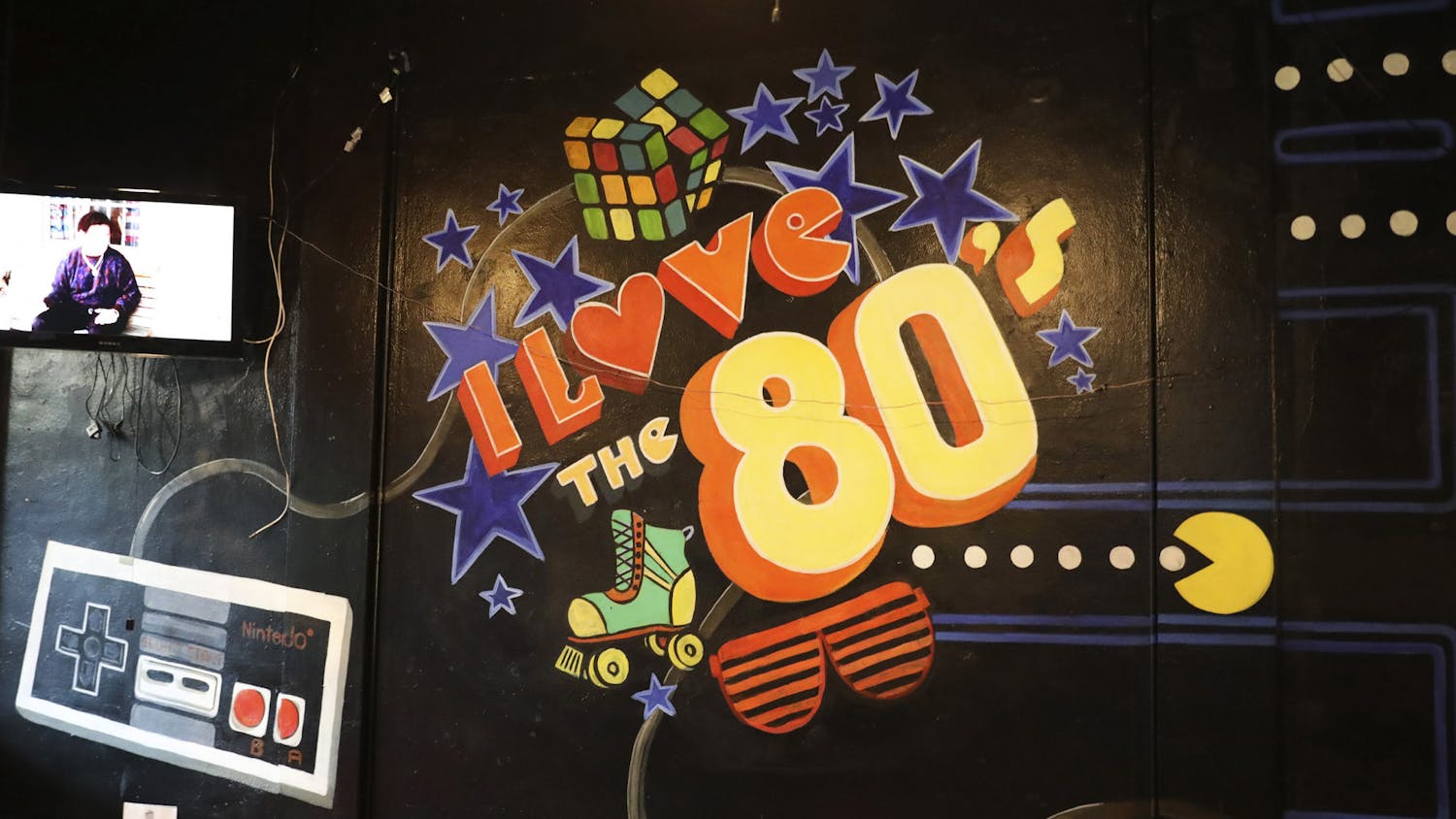 A Pac-Man wall painting that reads "I Love the 80s" sits on a wall of That 80s Bar Gainesville, located on West University Avenue on Friday, June 6, 2021.