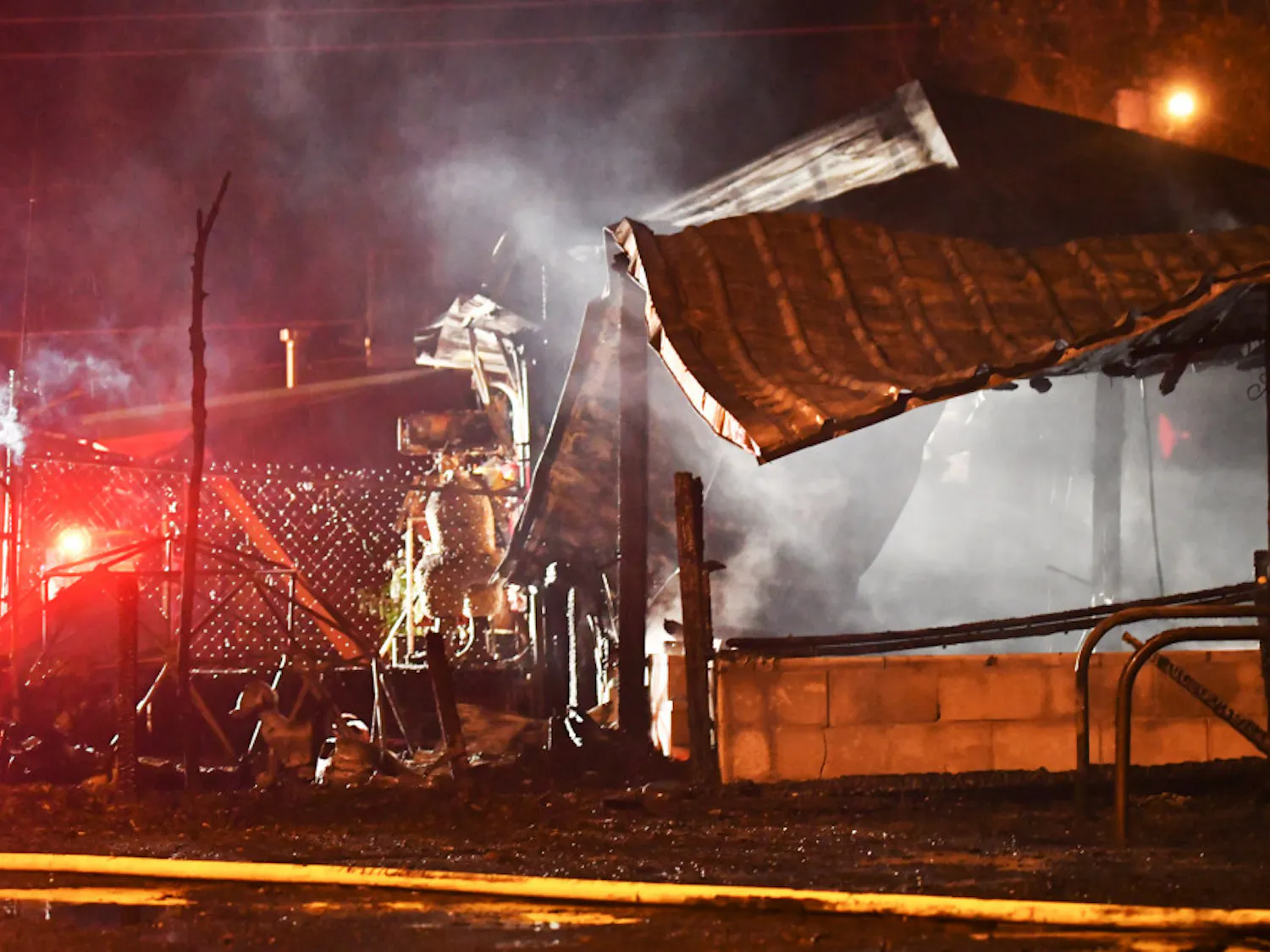 The tin roof of Lightnin’ Salvage sits in pieces as firefighters search the area for hotspots on Monday evening. The main dining room was not touched by the fire.