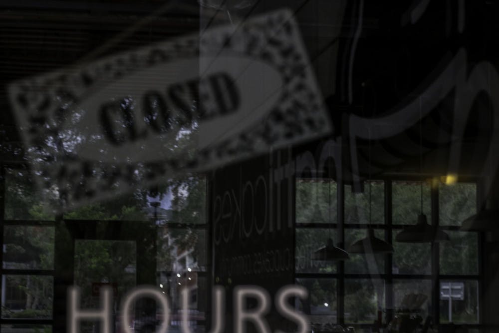 The sign for Patticakes in Bo Diddley Plaza is reflected Monday evening in the window of the closed coffee shop.