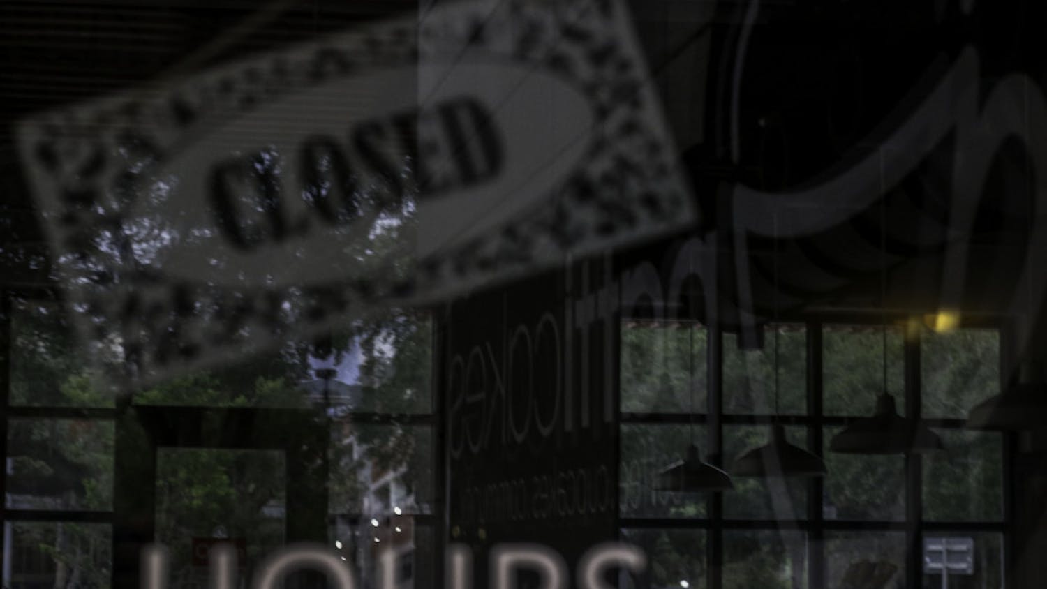 The sign for Patticakes in Bo Diddley Plaza is reflected Monday evening in the window of the closed coffee shop.