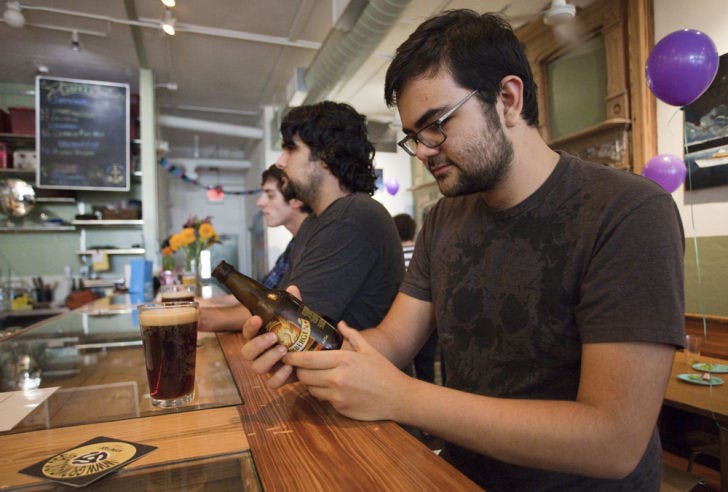 Chris James, 26, studies a bottle of Grimbergen Dubbel beer in preparation for a monthly meet up among him, his friend Jordan Williams, 22, and a few others, who discuss computer and IT security together.&nbsp;
&nbsp;