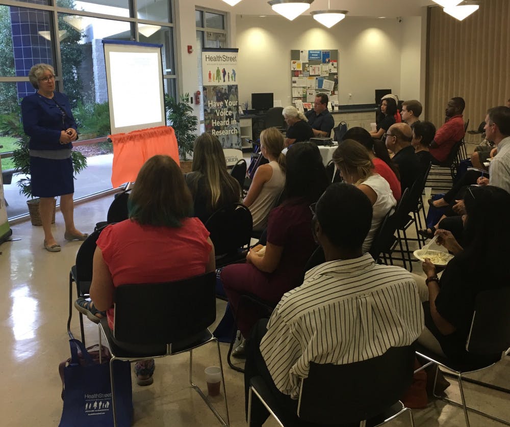 Catherine Striley, a co-director of HealthStreet, gives a PowerPoint presentation on the dangers of opioid drugs to about 25 Gainesville residents on Wednesday evening ahead of a panel discussion live-viewing, hosted by the UF Health Community Engagement Center.