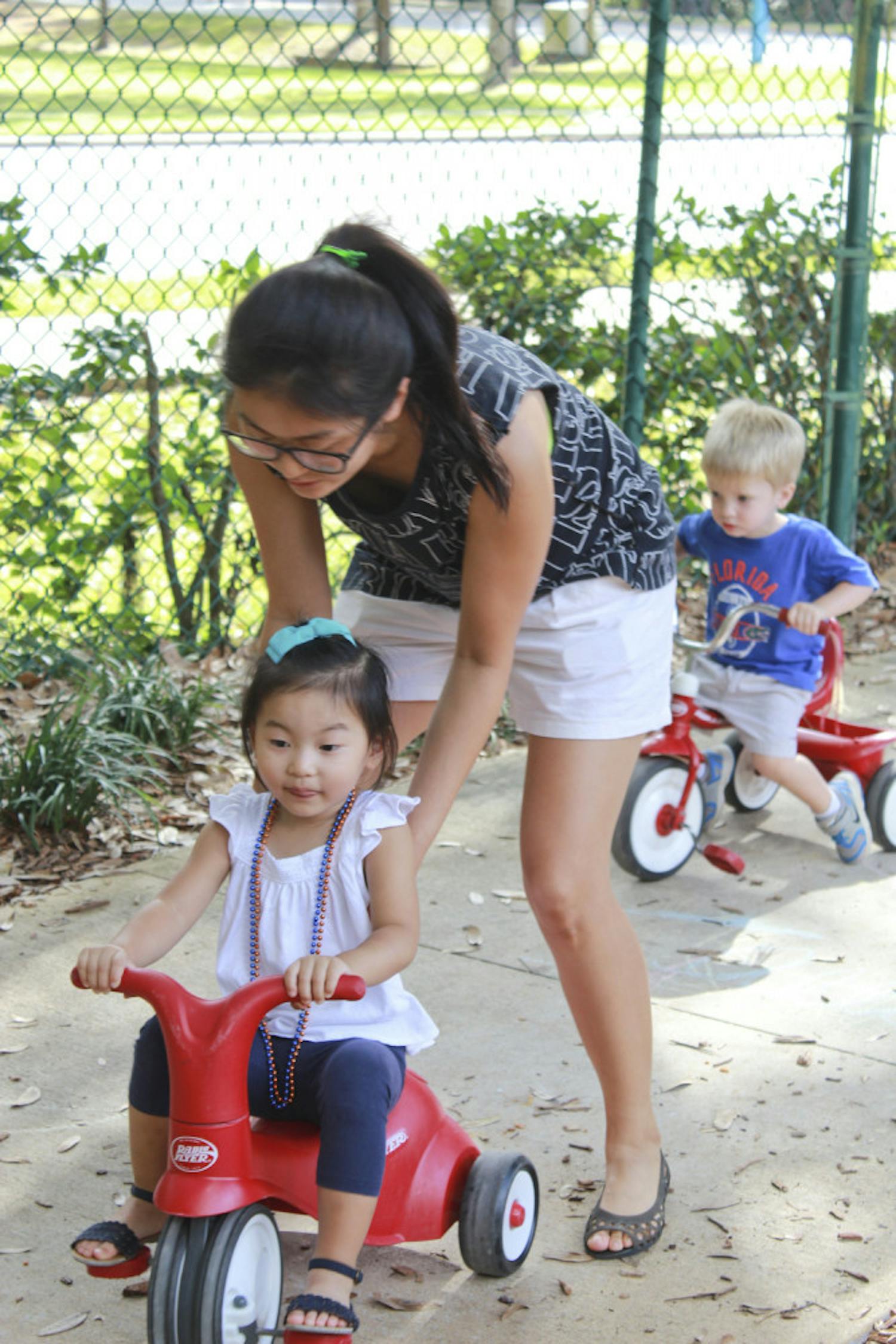 Former UF PhD student Soon Hye Yang, 34, pushes her 3-year-old daughter, Isu Yoon, on a tricycle at the Baby Gator daycare center on Nov. 5, 2015. Baby Gator’s request for additional funding was denied, and without it, student parents like Yang may be cut from the program.