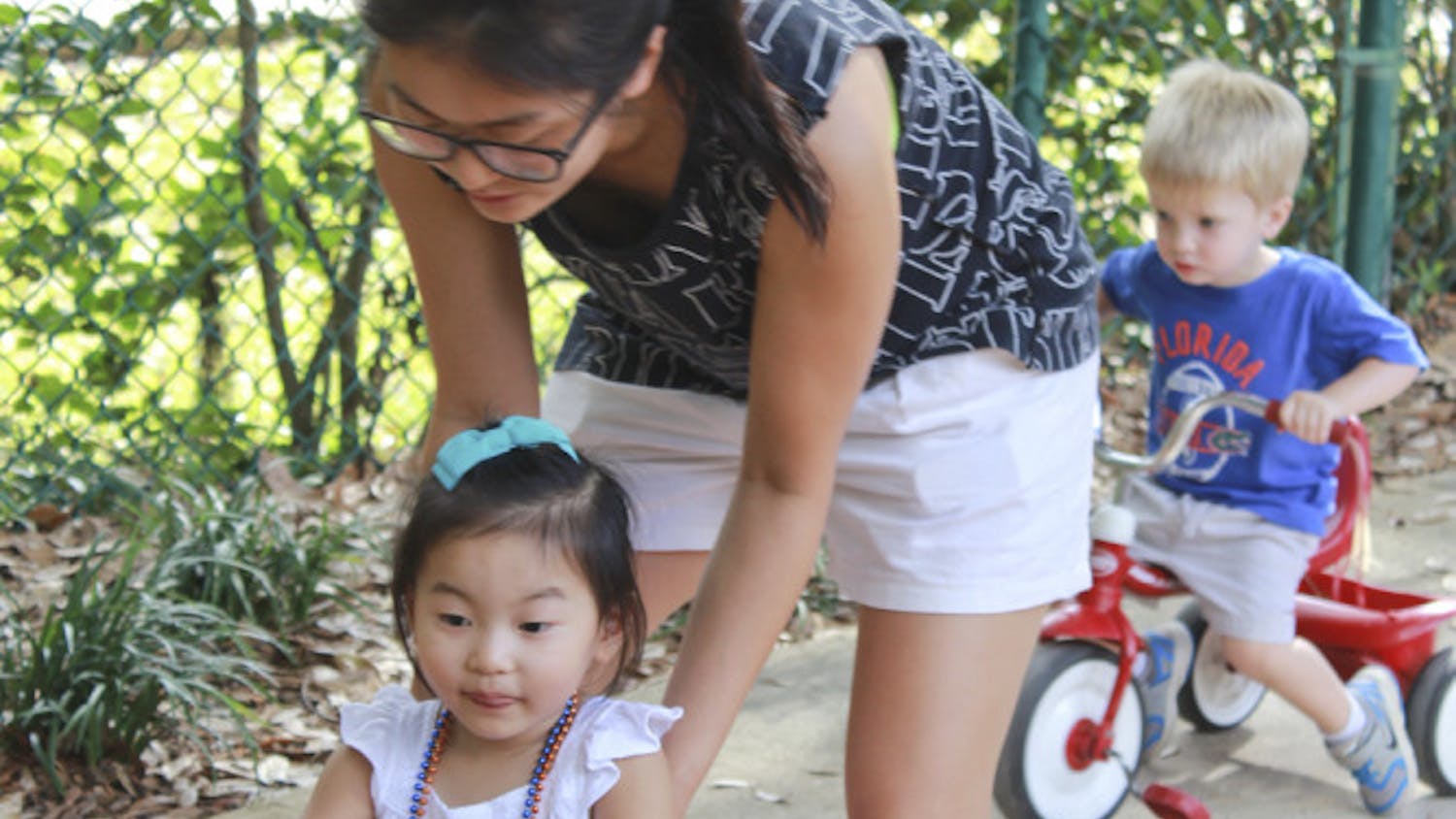 Former UF PhD student Soon Hye Yang, 34, pushes her 3-year-old daughter, Isu Yoon, on a tricycle at the Baby Gator daycare center on Nov. 5, 2015. Baby Gator’s request for additional funding was denied, and without it, student parents like Yang may be cut from the program.