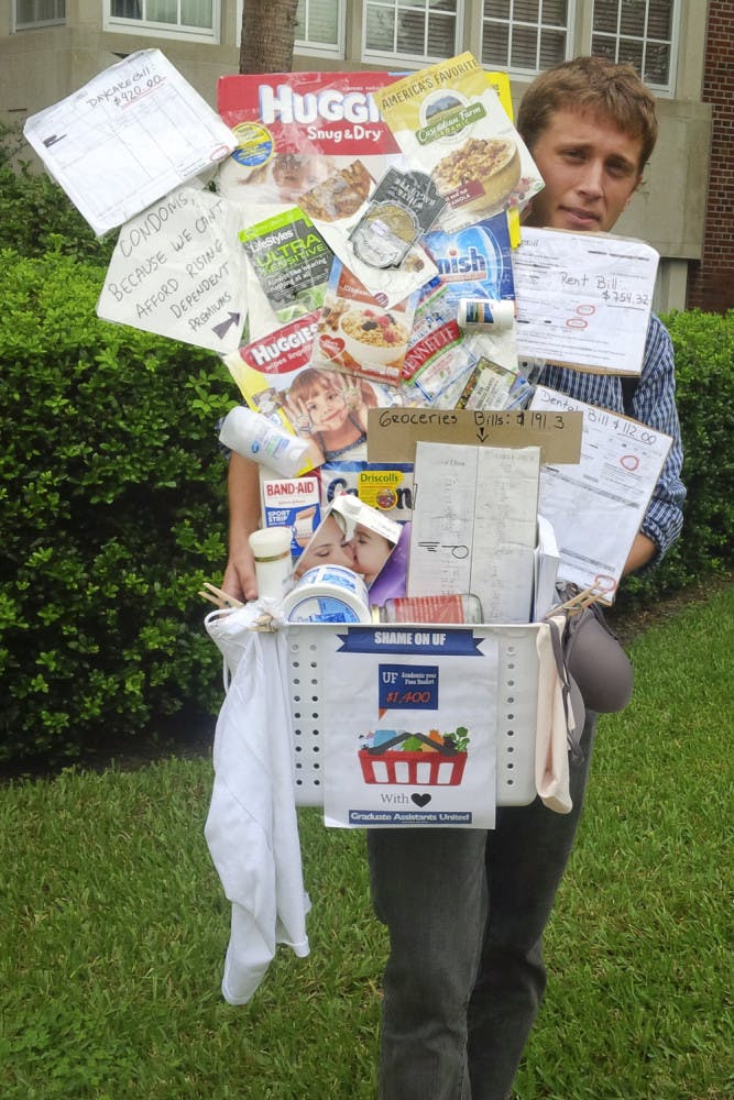 Outside Tigert Hall, the Co-President of Graduate Assistant United Alec Dunnin prepares to deliver a basket filled with items graduate students can’t afford because of university fees on Nov. 19, 2015. The 27-year-old UF political science PhD student said GAU wanted to make the $720 fee real and visible in a creative way.