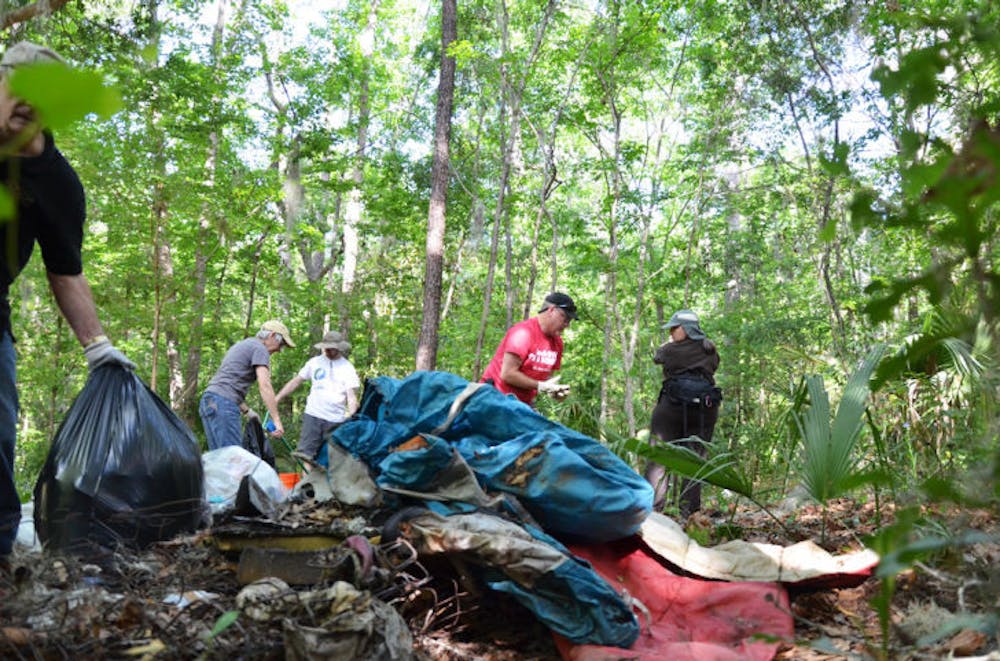 <p>Volunteers clean up Hogtown Creek near Lowe's Home Improvement, 2564 NW 13th St., on Saturday. Volunteers picked up about 3,000 pounds of trash during the cleanup event.</p>