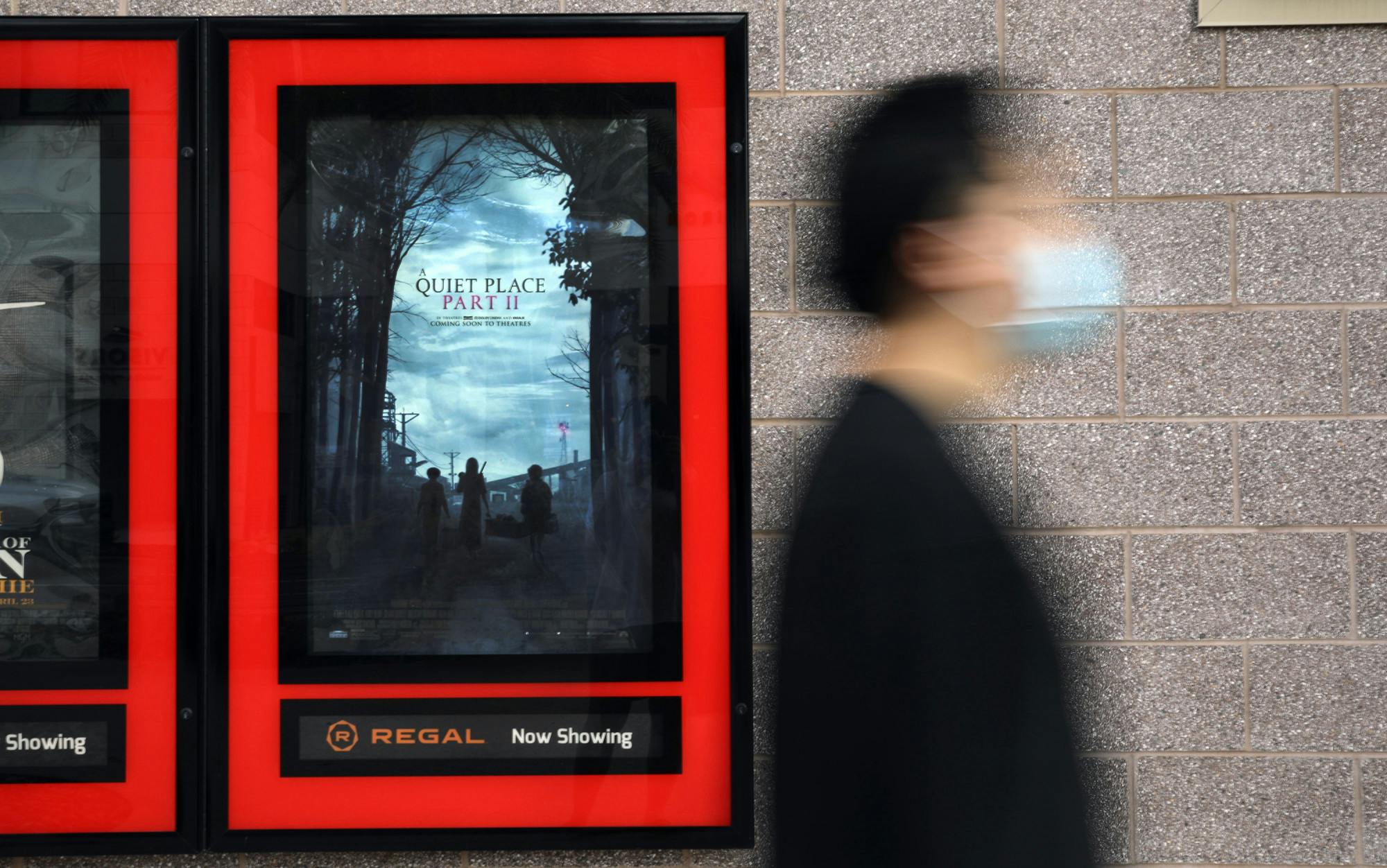 Haoxian Li, 24, an Orlando resident, walks past a movie poster for “A Quiet Place Part II” at Regal Celebration Pointe theater in Gainesville on Thursday, June 3, 2021. 