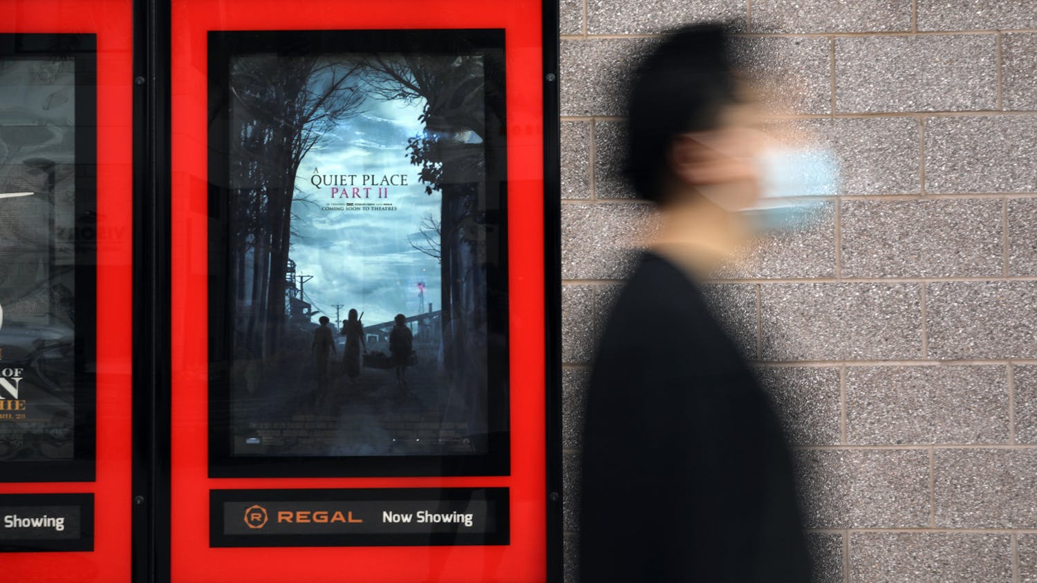 Haoxian Li, 24, an Orlando resident, walks past a movie poster for “A Quiet Place Part II” at Regal Celebration Pointe theater in Gainesville on Thursday, June 3, 2021. 