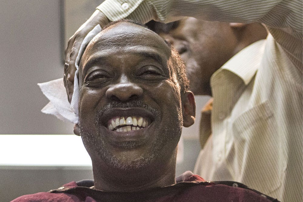 Vincent Tate, 51, receives a haircut Tuesday from Edward Young, 64, at the Clean Cut Barber Shop on Northwest Fifth Avenue. Tate moved from Alabama to Gainesville for a fresh start, and he has worked for the Alachua County School Board for 25 years.