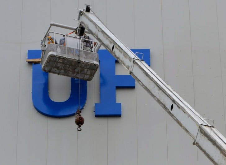 Rebranding - Construction workers hang a new sign on the southside of Ben Hill Griffin Stadium Thursday afternoon.