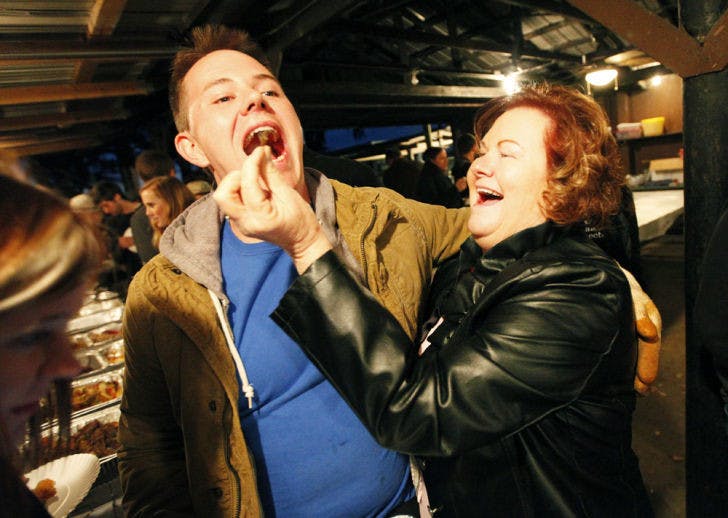 Carrol Godwin, 53, feeds her son Cody Godwin, 23, a UF wildlife ecology and conservation senior, a fried Cuban anole, a species of invasive lizards, during the 30th Annual Beast Feast presented by the UF Wildlife Society. The lizards were caught on UF campus and served as part of the wild game dinner buffet.