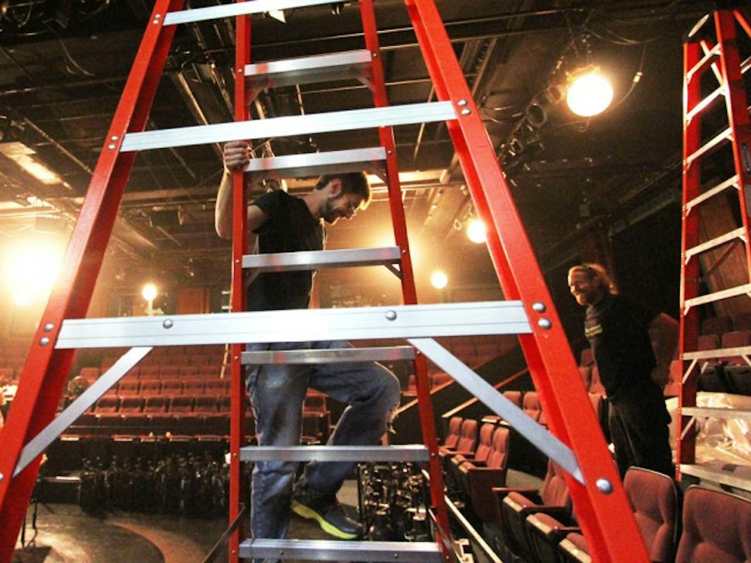 Josh Allen, 27, (left) and Nelson Isaac, 41, (right) work on lighting for the upcoming show “Carrie” at the Hippodrome State Theatre on Monday.