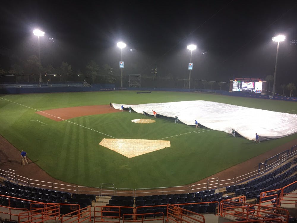 <p>The tarp is pulled over the field as rain falls at McKethan Stadium during Florida's canceled game against Stetson on Tuesday night.</p>