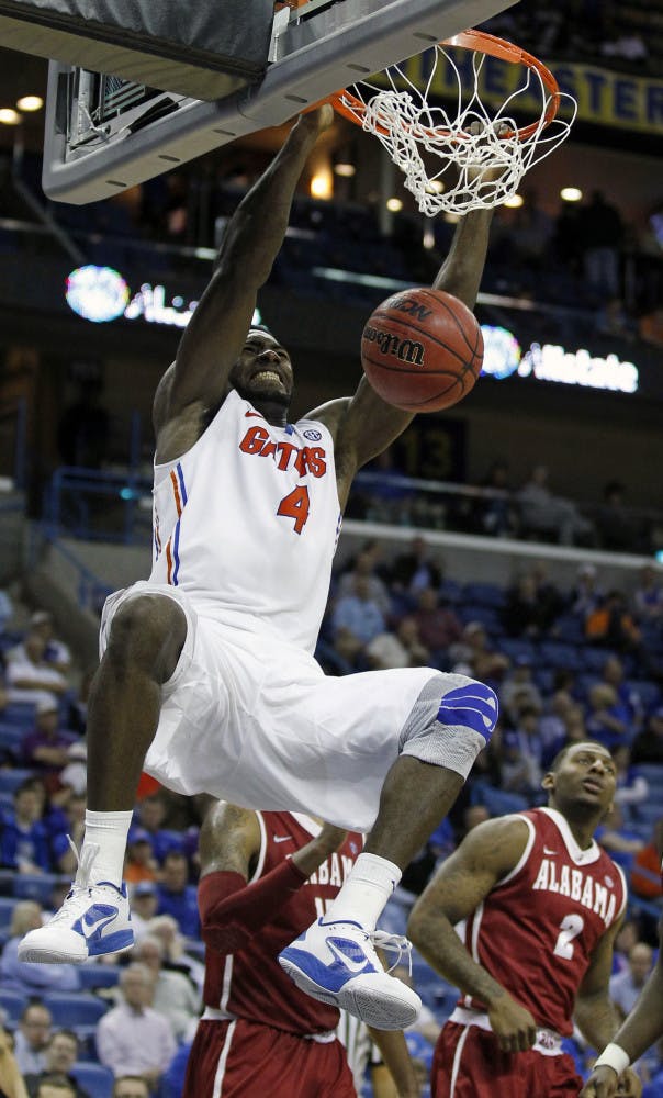Florida's Patric Young (4) dunks the ball as Alabama guard Charles Hankerson Jr. (2) watches during the second half of the Gators' 66-63 win in the SEC Tournament on Friday.