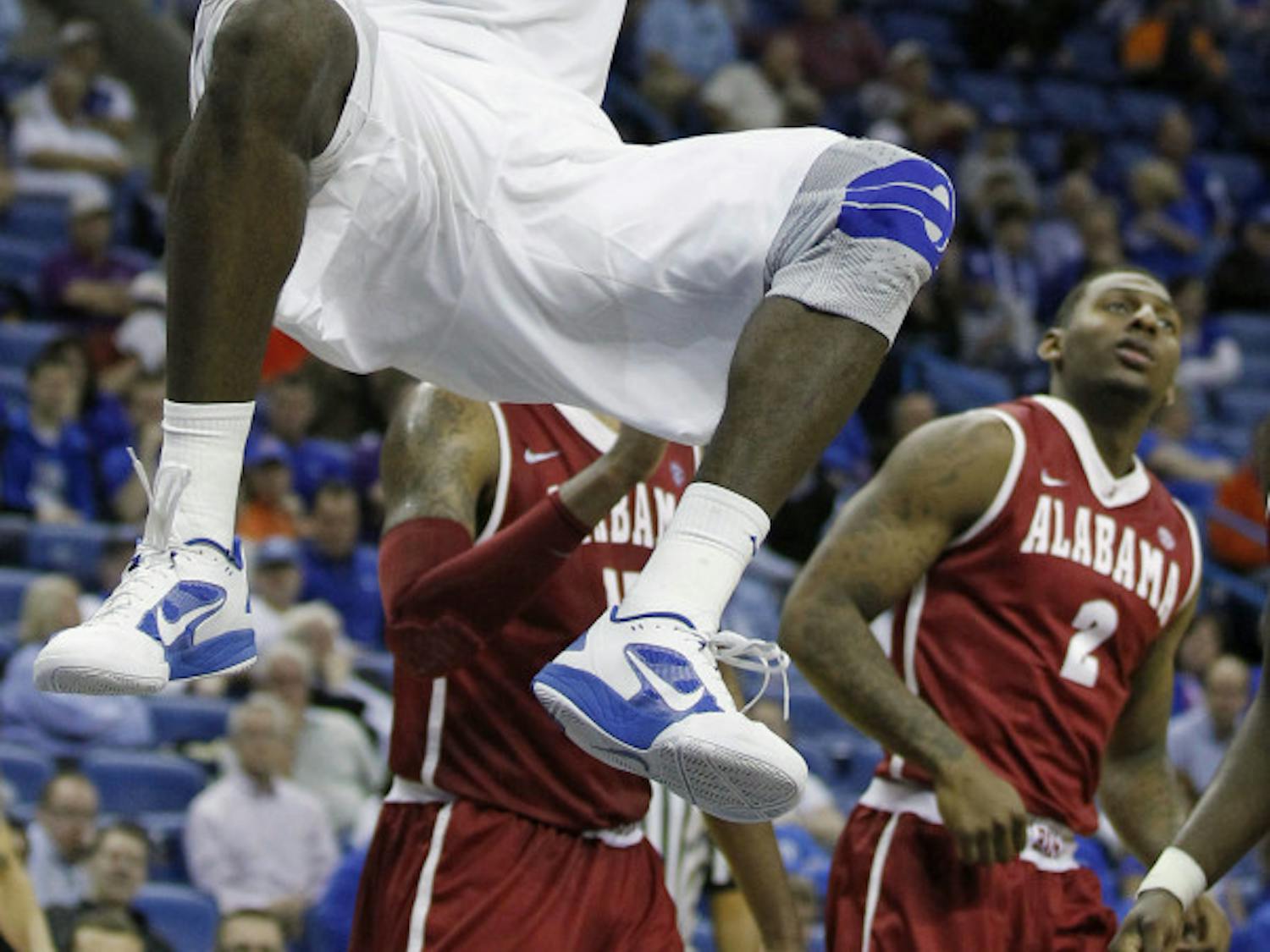 Florida's Patric Young (4) dunks the ball as Alabama guard Charles Hankerson Jr. (2) watches during the second half of the Gators' 66-63 win in the SEC Tournament on Friday.