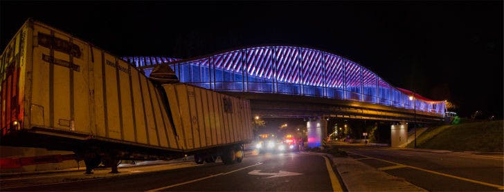 The northbound lanes of the 2100 block of Southwest 13th Street were closed Sunday night after the DNA bridge knocked a trailer off a tow truck near Archer Road, as seen in this stitched photo. The trailer had been damaged in a previous accident, said Sgt. Barry Kays of Gainesville Police. The Florida Department of Transportation deemed the bridge safe.&nbsp;The truck “was riding a little high, and he hit the top on the bridge,” said a University Towing employee.